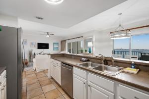 una cocina con fregadero y refrigerador en South Harbour 07B, en Pensacola Beach
