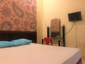 a bedroom with a bed and a tv and a chair at Wisma Idola Palopo in Palopo +40 photos