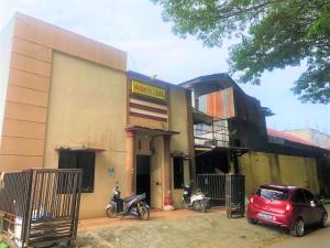 a red car parked in front of a building at Wisma Idola Palopo in Palopo