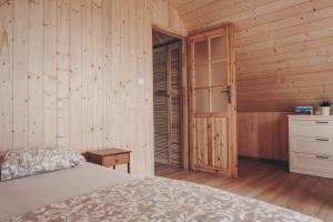 una camera con letto e parete in legno di JEZIORAKI Wyjątkowe domki 500m od jeziora Nowa Jedlanka a Uścimów