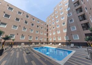 a swimming pool in front of a large building at APA Hotel & Resort Tokyo Bay Shiomi in Tokyo