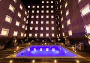 uma piscina em frente a um edifício à noite em APA Hotel & Resort Tokyo Bay Shiomi em Tóquio