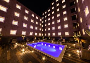 東京的住宿－APA Hotel & Resort Tokyo Bay Shiomi，夜间酒店庭院的游泳池
