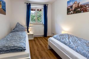 een slaapkamer met 2 bedden en een raam bij Omas Obstkiste in Stockach