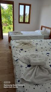 a room with three beds and a window at Guest House Qafe Dardha - Tomorr National Park in Dardhë