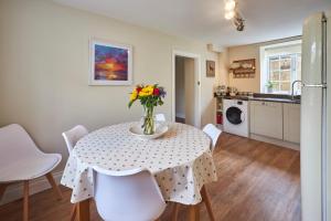 a kitchen with a table with a vase of flowers on it at Host & Stay - North Cottage in Newbrough