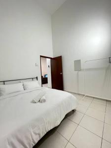 a bedroom with a white bed and a mirror at NZAK Homestay, Melaka in Malacca