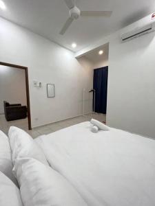 a bedroom with a large white bed with a ceiling at NZAK Homestay, Melaka in Malacca