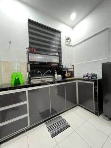 a kitchen with a black counter top in a room at NZAK Homestay, Melaka in Malacca