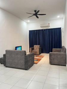 a living room with two couches and a ceiling fan at NZAK Homestay, Melaka in Malacca