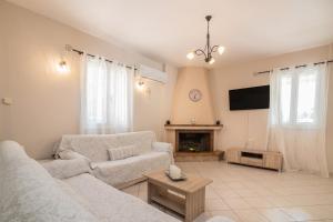 a living room with two couches and a fireplace at Planos Villa in Tsilivi