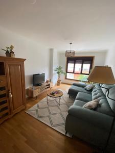 sala de estar con sofá y TV en Casa Sanjurjo, en Monforte de Lemos