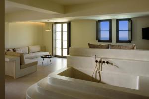 - un salon avec un lavabo et un canapé dans l'établissement Elessa Hotel, à Pyrgos