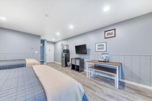 1 dormitorio con 1 cama, escritorio y TV en Sea Treasures Inn Units #205-212, en Rockaway Beach