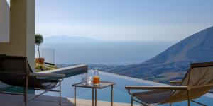 einen Balkon mit 2 Stühlen und einem Tisch mit Aussicht in der Unterkunft Elessa Hotel in Pirgos