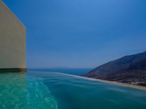 una piscina a sfioro con vista sull'oceano sullo sfondo di Elessa Hotel a Pyrgos