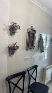 Habitación con 2 sillas, reloj y flores en Casa Sanjurjo, en Monforte de Lemos