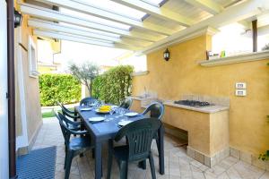 eine Terrasse mit einem Tisch und Stühlen sowie eine Küche in der Unterkunft Villa Iris in Manerba del Garda
