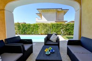 a patio with chairs and a table and a pool at Villa Iris Manerba private pool in Manerba del Garda