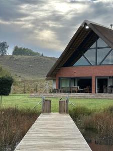 a building with a wooden boardwalk in front of it at The Fisherman's Cottage in Mooirivier