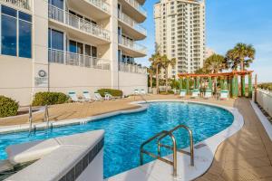 a swimming pool with chairs and a building at Pearl 1602 in Navarre