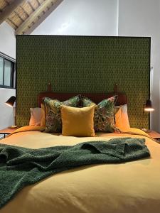 a bedroom with a large bed with a green headboard at The Fisherman's Cottage in Mooirivier