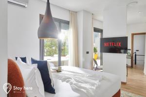 una camera da letto con un letto bianco e un cartello Nightisk sul muro di Stayhere Casablanca - Gauthier 2 - Contemporary Residence a Casablanca