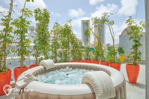 a hot tub on a rooftop with potted plants at Stayhere Casablanca - Gauthier 2 - Contemporary Residence in Casablanca