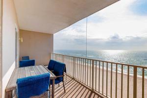 a balcony with a table and chairs and the ocean at Windemere 0805 in Perdido Key