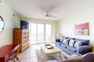 a living room with a blue couch and a table at Windemere 0805 in Perdido Key