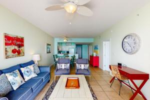 a living room with a blue couch and a table at Windemere 0805 in Perdido Key