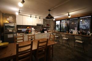 una cocina con mesa de madera y sillas en un restaurante en Bunk Guesthouse Hongdae, en Seúl