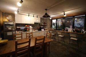 a kitchen with a wooden table and chairs in a restaurant at Bunk Guesthouse Hongdae in Seoul