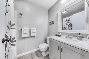 a white bathroom with a toilet and a sink at Sea Treasures Inn #211 & #212 in Rockaway Beach