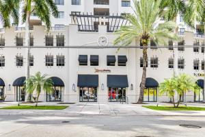 un edificio con palmeras delante en Stylish Modern Apartments at Gables Grand Plaza in Miami en Miami