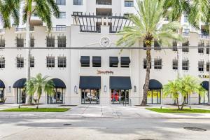 un edificio con palmeras delante en Stylish Modern Apartments at Gables Grand Plaza in Miami, en Miami