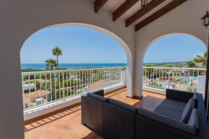 een balkon met een bank en uitzicht op de oceaan bij Villa Belvedere 76 in Son Bou