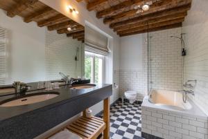 a bathroom with two sinks and a tub and a toilet at Fletcher Hotel Château De Raay in Baarlo +74 photos