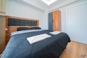 1 dormitorio con 1 cama grande con manta negra en ELEGANCE PRESTİGE en Kayseri