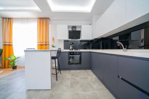 una cocina con armarios en blanco y negro y fregadero en ELEGANCE PRESTİGE en Kayseri