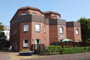 a red brick building with a black roof at Kapitän's Koje Wangerooge in Wangerooge