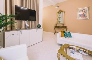 a living room with a white couch and a flat screen tv at TIZIANA'S HOUSE in Salerno