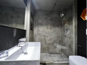 a bathroom with a white sink and a shower at Urban Suite in Corato
