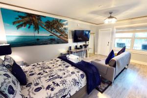 ein Schlafzimmer mit einem Bett und einem Gemälde des Ozeans in der Unterkunft Ocean Jewel Condos Unit 244 in Daytona Beach