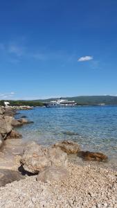 een groep rotsen aan de oever van een waterlichaam bij Studio Apartments Maslinik in Krk