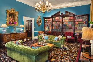 un soggiorno con divano e librerie di The Gore London - Starhotels Collezione a Londra