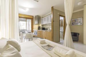 a bedroom with a white bed and a kitchen at Ice Apartment - Free Wifi in Quartu SantʼElena