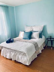 ein blaues Schlafzimmer mit einem großen Bett mit Kissen in der Unterkunft Classic Holiday in New Germany
