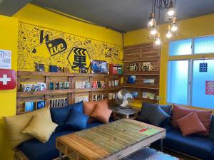a living room with a blue couch and a table at Hive Bed and Backpacker蜂巢膠囊旅店 in Hualien City