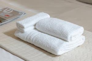 a stack of white towels sitting on a bathroom counter at Ice Apartment - Free Wifi & Parking in Quartu SantʼElena +37 photos